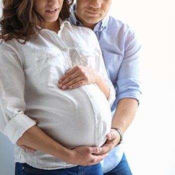 Pregnant woman with her husband on white background. Space for text